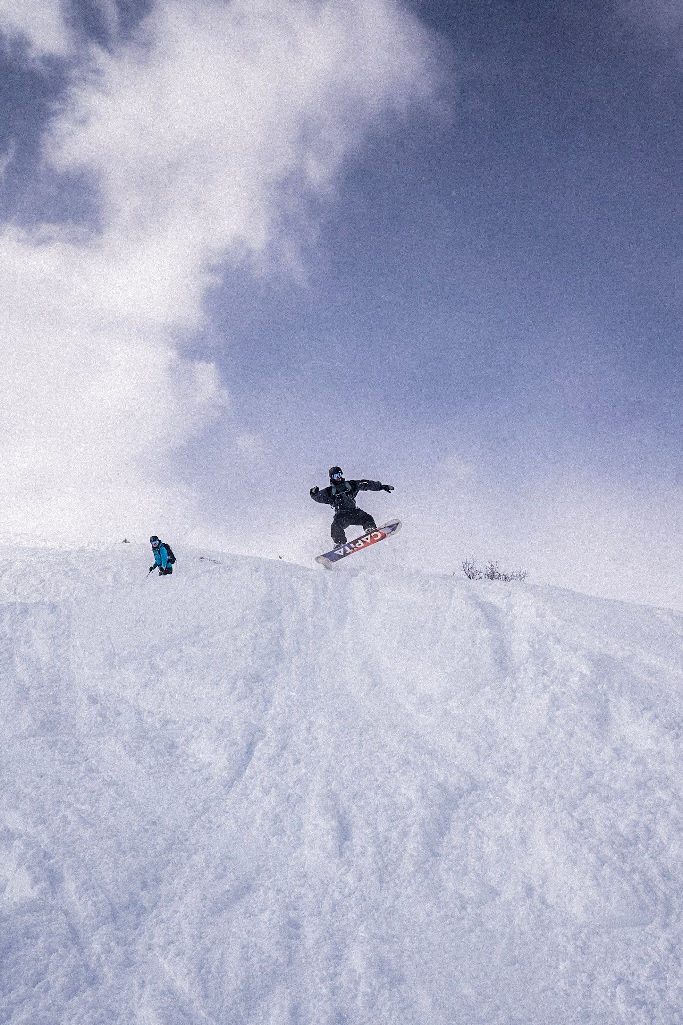 Snowboarder springt über einen Schneehügel